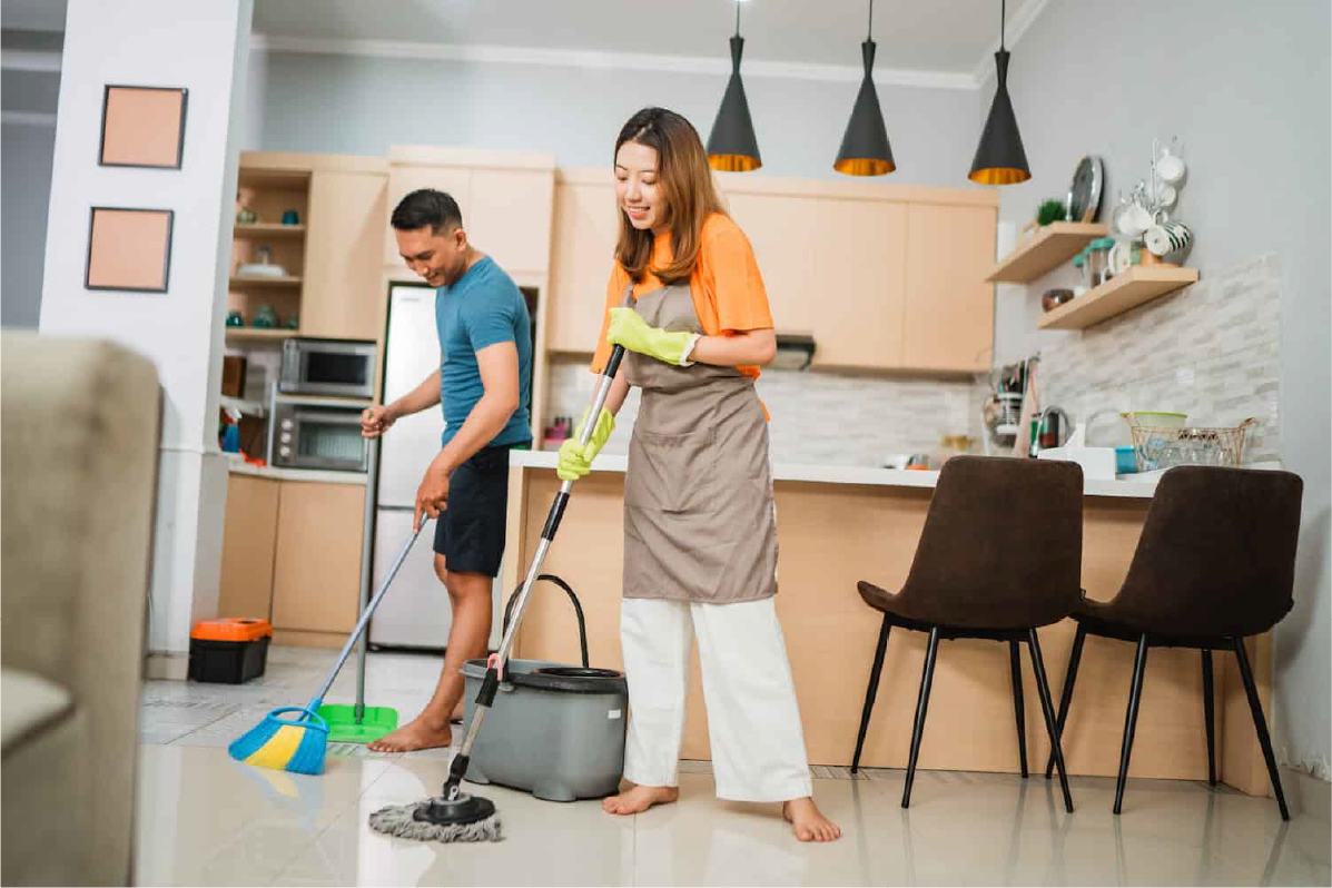 Two people sharing household chores, sweeping and mopping the kitchen floor